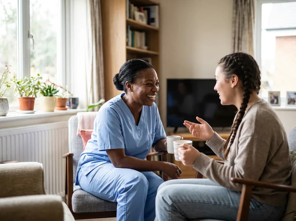 Focus Family Care companion caregiver laughing with a senior at his kitchen table
